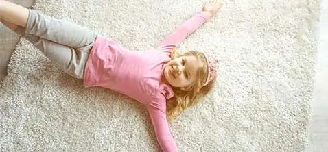 Cute girl lying on carpet | All American Remnants & Rolls